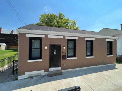 a small brown house with a door on a sidewalk at Luxury 2BR within walking distance to Nightlife!! in Covington