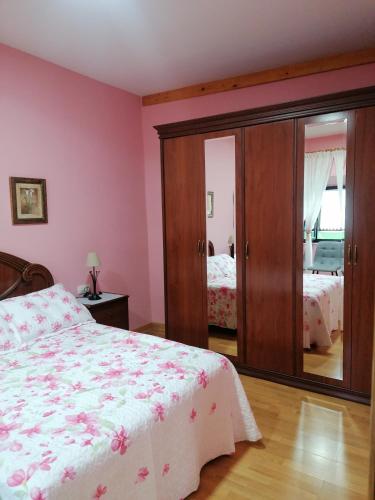 a bedroom with pink walls and a bed and a mirror at NIDO in Ribadeo