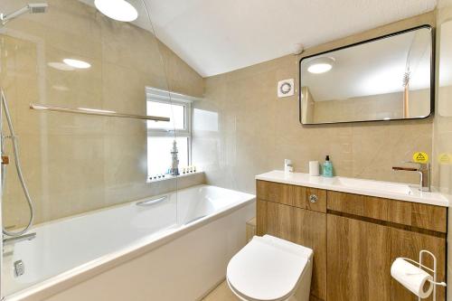 La salle de bains est pourvue d'une baignoire, de toilettes et d'un lavabo. dans l'établissement Just Stay Wales - Castle Square Cottage, Mumbles, à Oystermouth