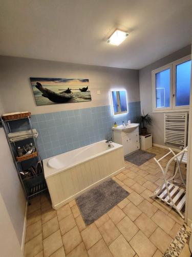a large bathroom with a tub and a sink at Chambre d'Hote Woody in Chef-Boutonne