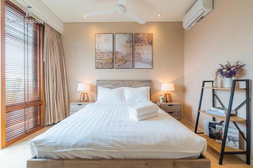 a bedroom with a large white bed with two lamps at Park view Avalon Apartment District 1 HCM City in Ho Chi Minh City