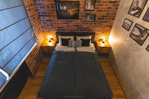 Da Vinci Apartment في Vratsa: غرفة صغيرة مع سرير في جدار من الطوب