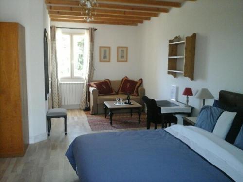 Un dormitorio con una cama y una sala de estar. en La Dentellière, en Saint-Hippolyte-le-Graveyron