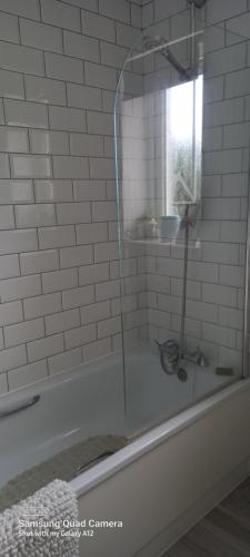 a shower with a glass door in a bathroom at 2 Orchard Gate in Kent