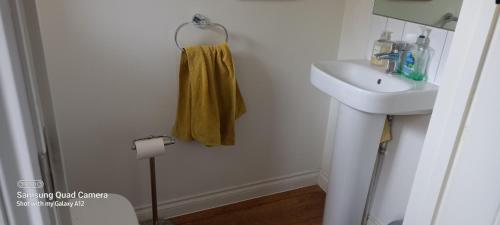 a bathroom with a sink and a towel hanging on the wall at 2 Orchard Gate in Kent