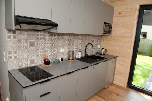 uma cozinha com um lavatório e uma bancada em Kapitanka Apartamenty em Okuninka