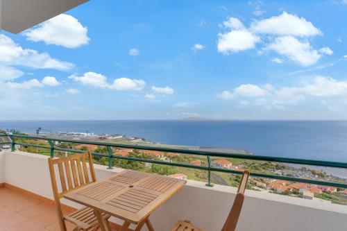 balcone con tavolo, sedie e vista sull'oceano di Santa Cruz Apartment with Sea View by HR Madeira a Santa Cruz