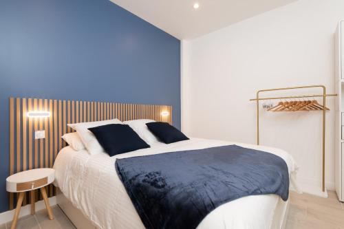 une chambre avec un grand lit avec un mur bleu dans l'établissement Modern Apartment - Promenade des Anglais in Nice, à Nice