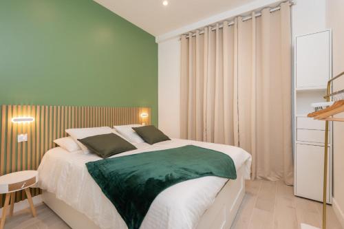 une chambre avec un grand lit avec des draps verts dans l'établissement Modern Apartment - Promenade des Anglais in Nice, à Nice