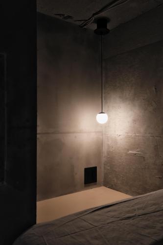 a dark room with a bed and a light at SHIN kyoto in Kyoto