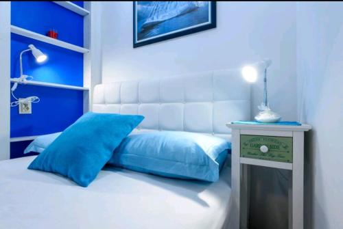 ein blau-weißes Schlafzimmer mit einem Bett und einem Nachttisch in der Unterkunft Apartman Gloria in Dubrovnik