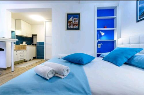 ein Schlafzimmer mit einem großen Bett mit blauen Kissen in der Unterkunft Apartman Gloria in Dubrovnik