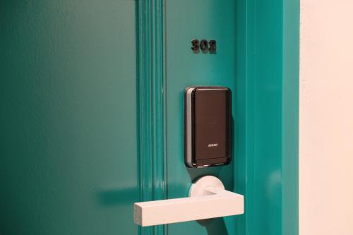 a door with a soap dispenser on a green door at SHIN kyoto in Kyoto