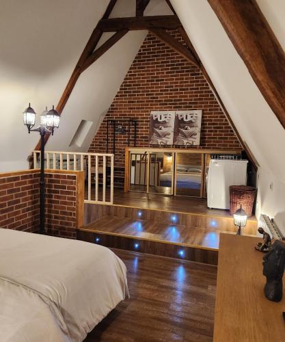 Zimmer mit einem Bett und einer Ziegelwand in der Unterkunft Duplex cosy Life Balnéo in Cysoing