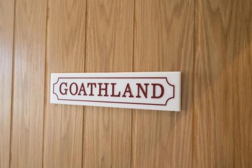 um sinal numa porta de madeira com a palavra gótico em Lettered Board Apartments 1, 2 & 3 em Pickering