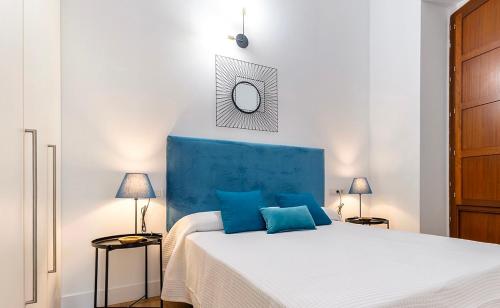 1 dormitorio con 1 cama grande y cabecero azul en Apartamentos Alicante Centro by Renthas, en Alicante
