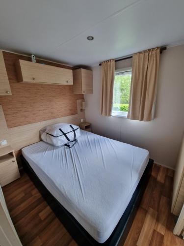 een groot bed in een kleine kamer met een raam bij 3 Bedroom Holiday Home at Siblu in Pont-Aven