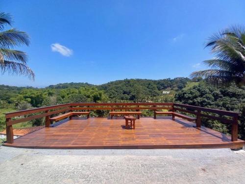 a wooden deck with a bench on top of it at Chácara Alegria - Um pedaço do paraíso em Itaboraí in Itaboraí
