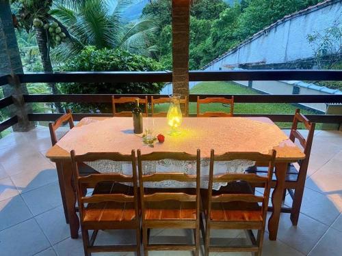 drewniany stół z krzesłami i świecą na balkonie w obiekcie Chácara Alegria - Um pedaço do paraíso em Itaboraí w mieście Itaboraí