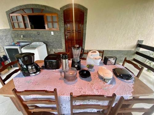 a table with a pink table cloth on it with a blender at Chácara Alegria - Um pedaço do paraíso em Itaboraí in Itaboraí