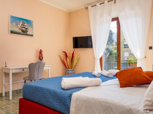 Schlafzimmer mit einem Bett, einem Schreibtisch und einem Fenster in der Unterkunft La Rosa Home Sorrento coast in Piano di Sorrento
