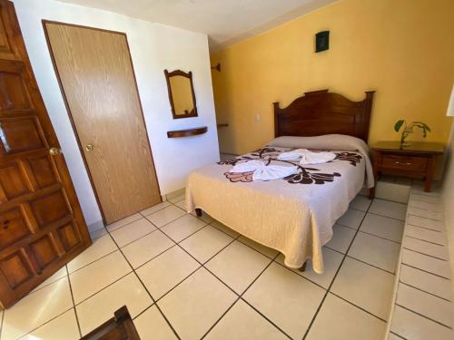 a hotel room with a bed and a mirror at HOTEL CAMELINAS AREA BLANCA in P&aacute;tzcuaro