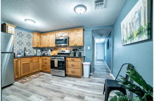 a kitchen with wooden cabinets and stainless steel appliances at Fascinating 2BR1BA Near Festive DT and Riverwalk in San Antonio