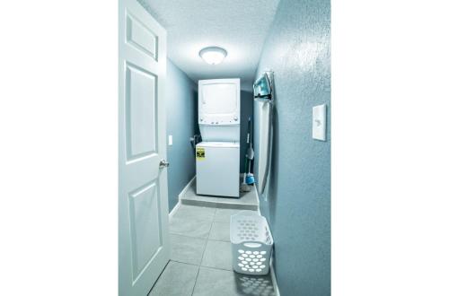 a small kitchen with a refrigerator and a door at Fascinating 2BR1BA Near Festive DT and Riverwalk in San Antonio