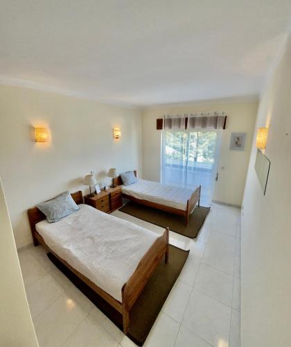 a bedroom with two beds and a window at Charming Salema in Salema