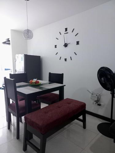 a dining room with a table and a clock on the wall at aparta hotel turístico a 2 km parque del café in Montenegro