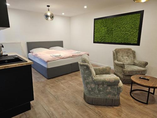 um quarto com uma cama e uma cadeira em Jalda Apartments em Dusseldorf