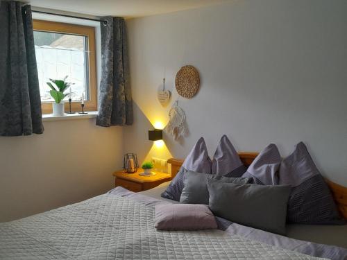 a bedroom with a bed with purple pillows and a window at Appartements Kumming in Rauris