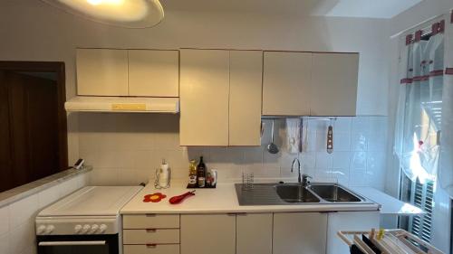 a small kitchen with white cabinets and a sink at Casa Elena in La Spezia