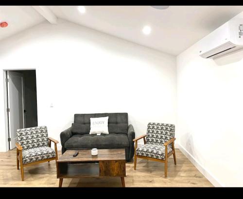 a living room with a black couch and two chairs at Gated private house with own parking Sherman Oaks in Los Angeles