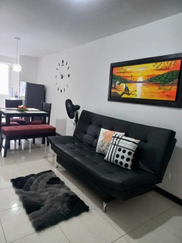 a black couch in a living room with a table at aparta hotel turístico a 2 km parque del café in Montenegro