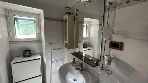 a white bathroom with a sink and a mirror at Casa Elena in La Spezia