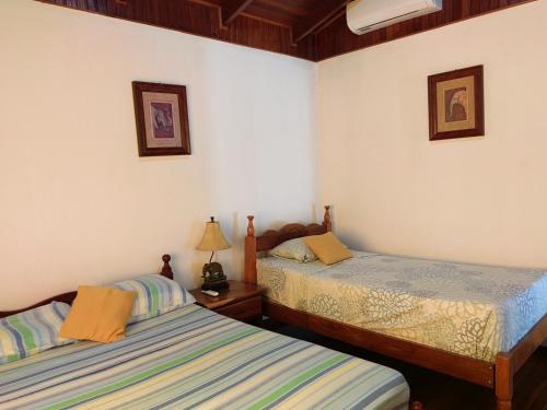 2 camas en una habitación con paredes blancas en Condominio Villa Hermosa en Playa Hermosa