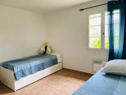 un dormitorio con una cama con un animal de peluche en Splendide villa 10p./4 suites/piscine/clim/paysage, en Bargemon