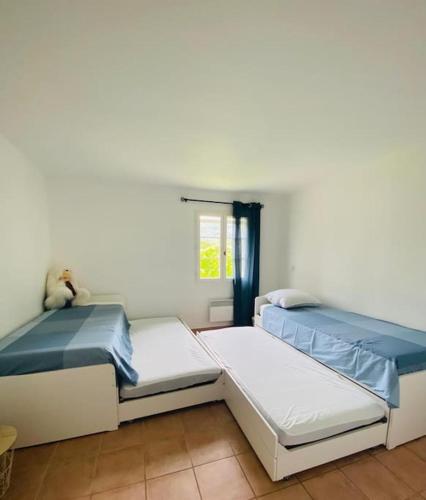 - 2 lits dans une chambre blanche avec un ours en peluche dans l'établissement Splendide villa 10p./4 suites/piscine/clim/paysage, à Bargemon