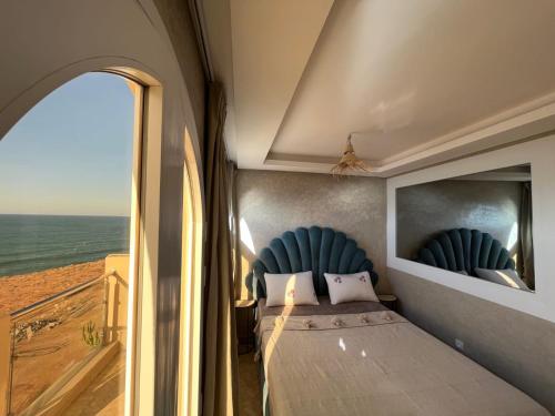 1 dormitorio con cama y vistas al océano en Dar diafa samira, en Mirleft