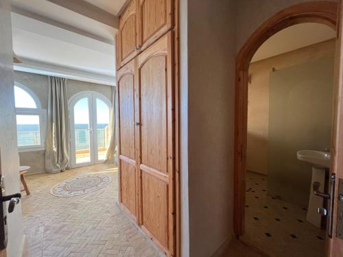 una puerta que conduce a una habitación con vistas al océano en Dar diafa samira, en Mirleft