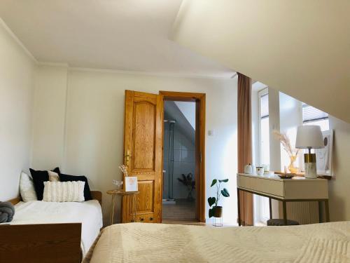 a bedroom with two beds and a door to a bathroom at Pokoje agroturystyczne U Hani in Ostrzyce
