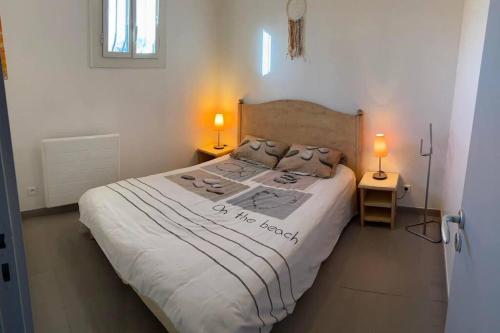 une chambre avec un grand lit blanc avec deux lampes dans l'établissement Charmant appartement à Port Grimaud, à Grimaud