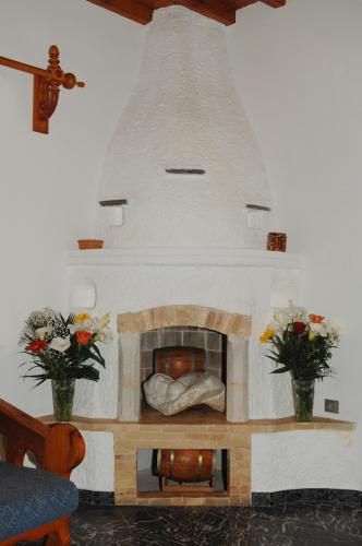 a fireplace in a living room with two vases at Villa Vasilis in Mýkonos City