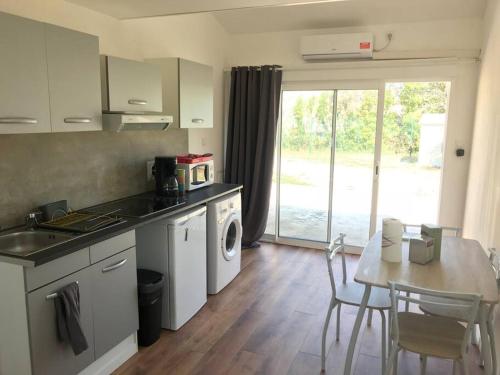 kuchnia ze stołem i stołem oraz jadalnia w obiekcie Loue Studio dans une villa avec piscine terrasse w mieście Saint-Théodorit