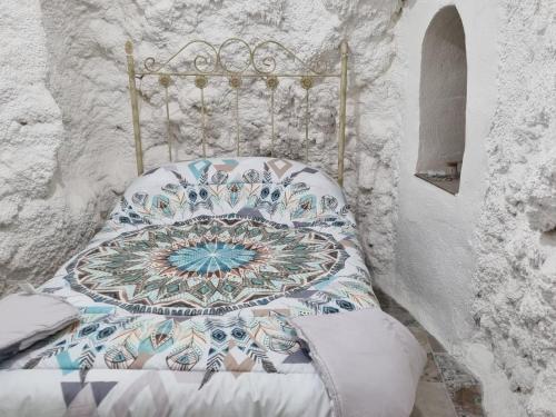 Casa rural El Parral في Bedmar: سرير عليه لحاف في غرفه
