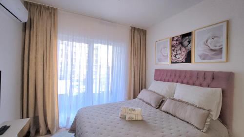 ein Schlafzimmer mit einem Bett und einem großen Fenster in der Unterkunft Studio apartment Lora Lux in Sarajevo