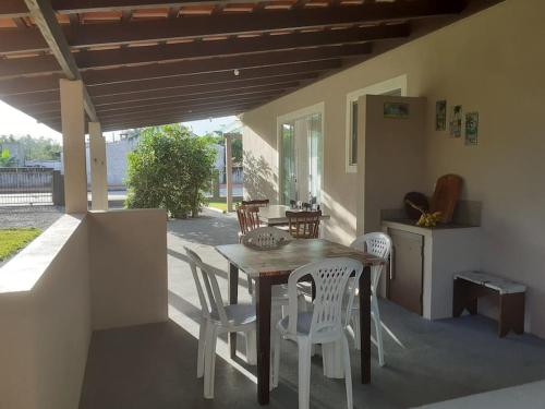 Une table et des chaises en bois sont disponibles sur la terrasse. dans l'établissement Férias Perfeitas, Praia e Piscina, à Itapoá