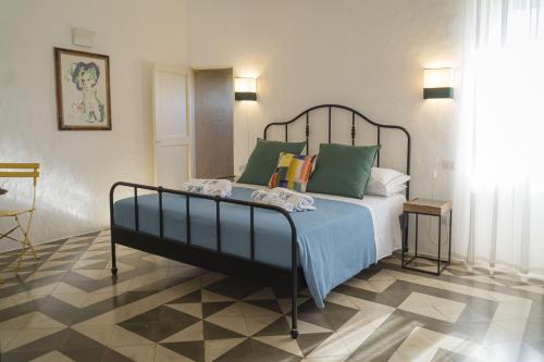 a bedroom with a bed with green pillows at Villa Romasi in Leuca