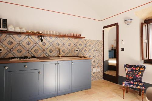 a kitchen with a blue cabinet and a chair at Rachel's House in Altamura